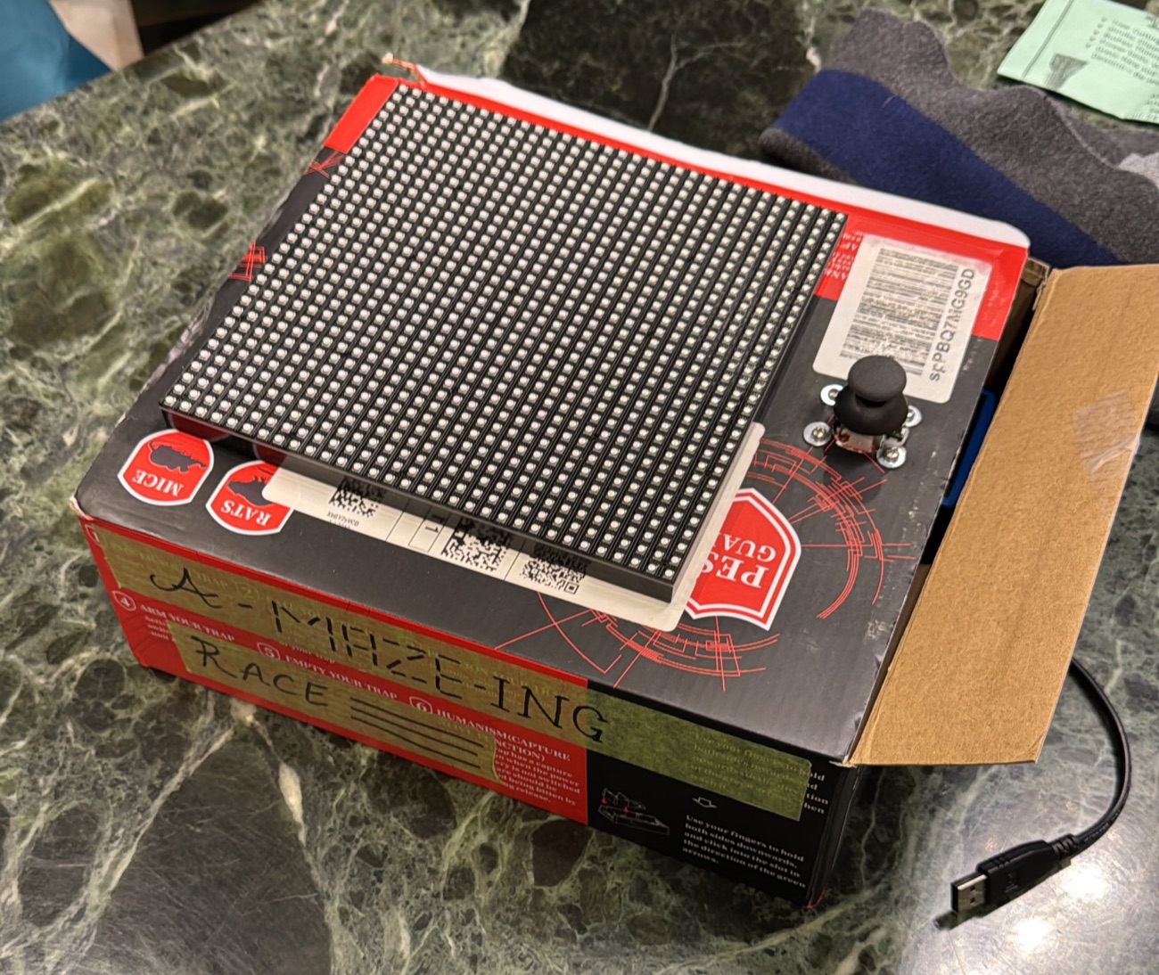 The original 2022 GRID build: a hand-labeled box with an LED matrix and joystick