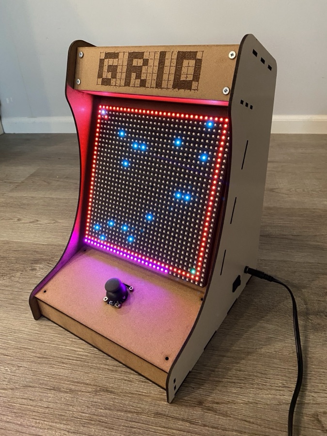 Photo of a mini-arcade system, showing an LED grid display with a joystick.